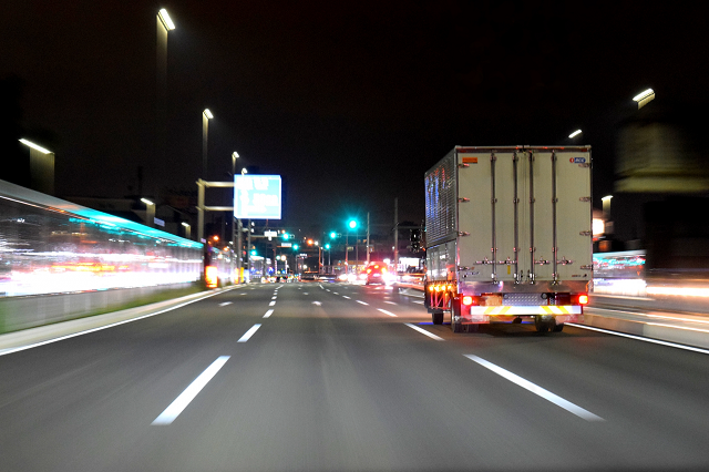 夜の高速道路を走行するトラック